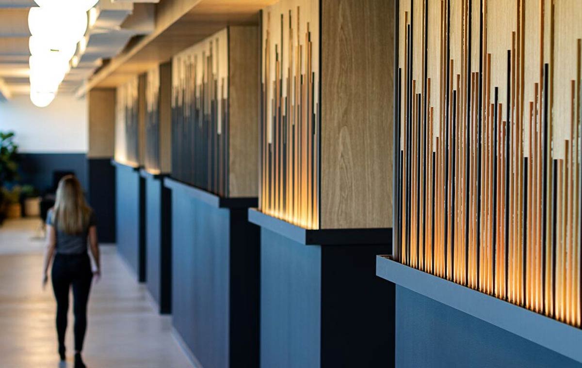 A stylized, textured corridor in an commercial building exemplifies environmental graphic design for corporate interiors